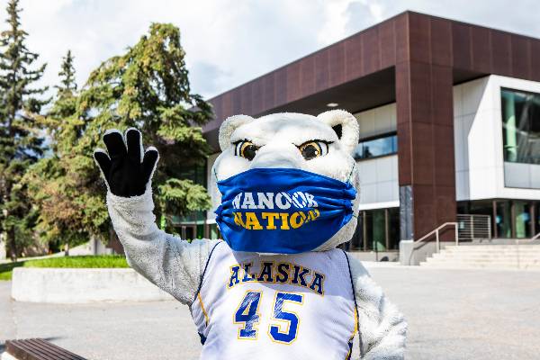 Nanook Mascot wearing a mask waving outside Wood Center